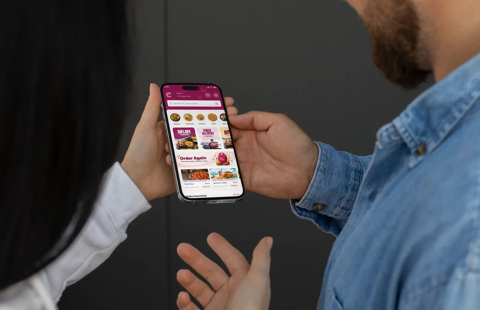 Two people viewing the Click To Food app together on a phone